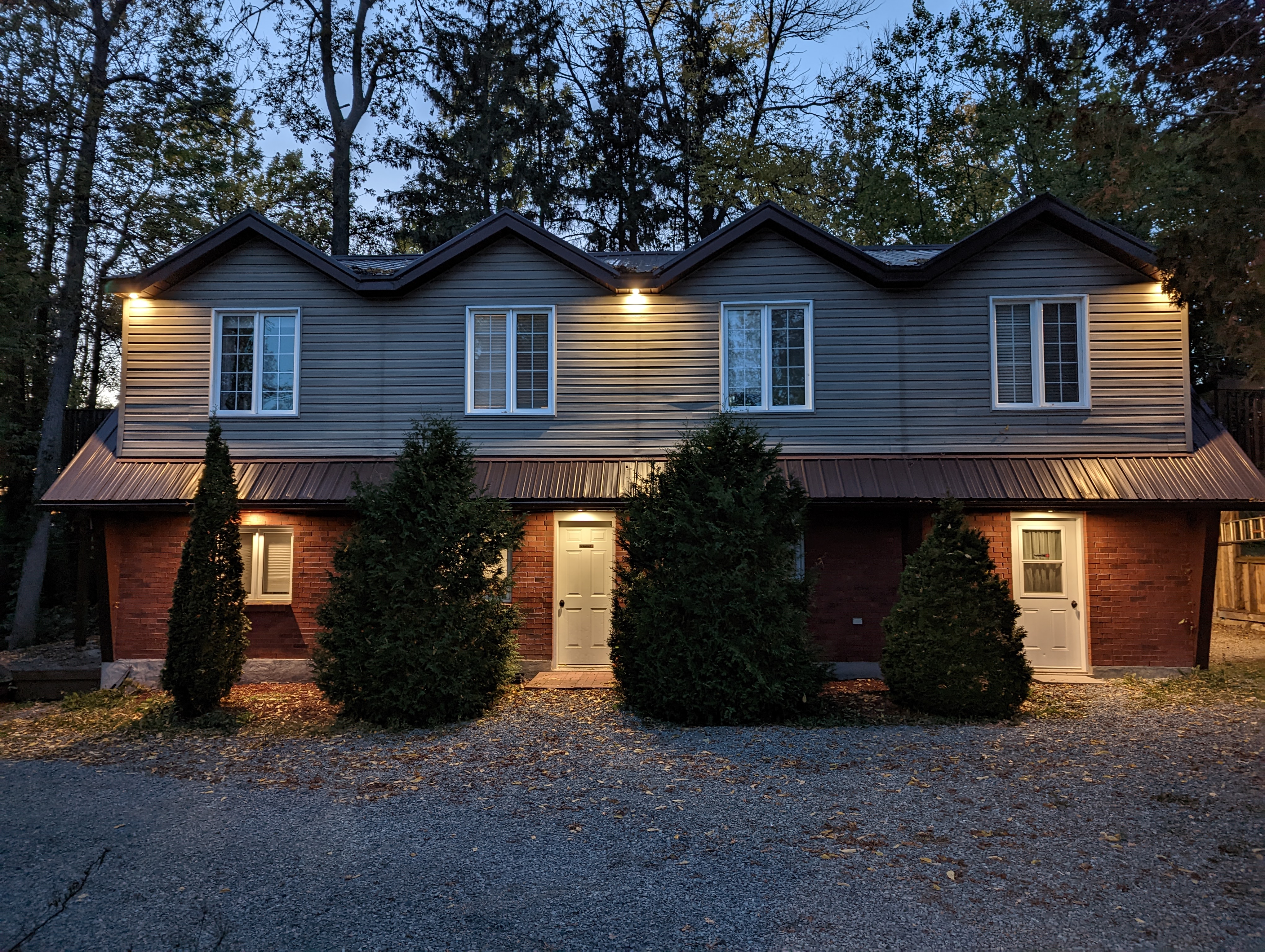 Chalet-style dwelling — front elevation at twilight, three-peak rooflines