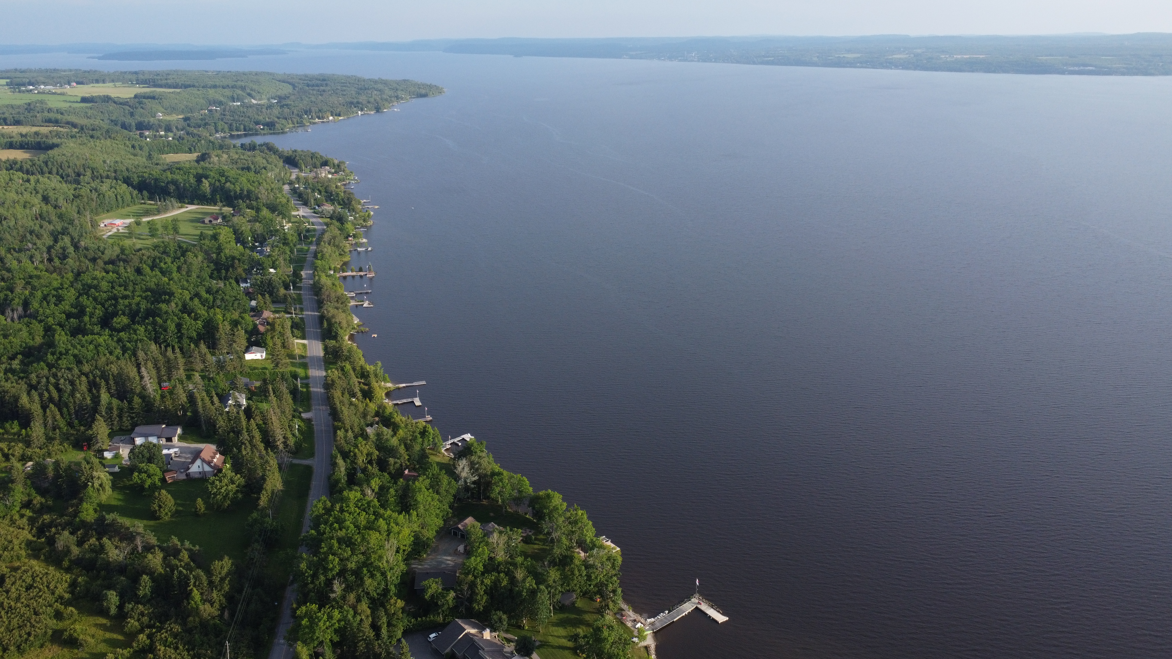 Aerial view of Lake Timiskaming looking south along the western shoreline, with Dawson Point Road and waterfront properties visible